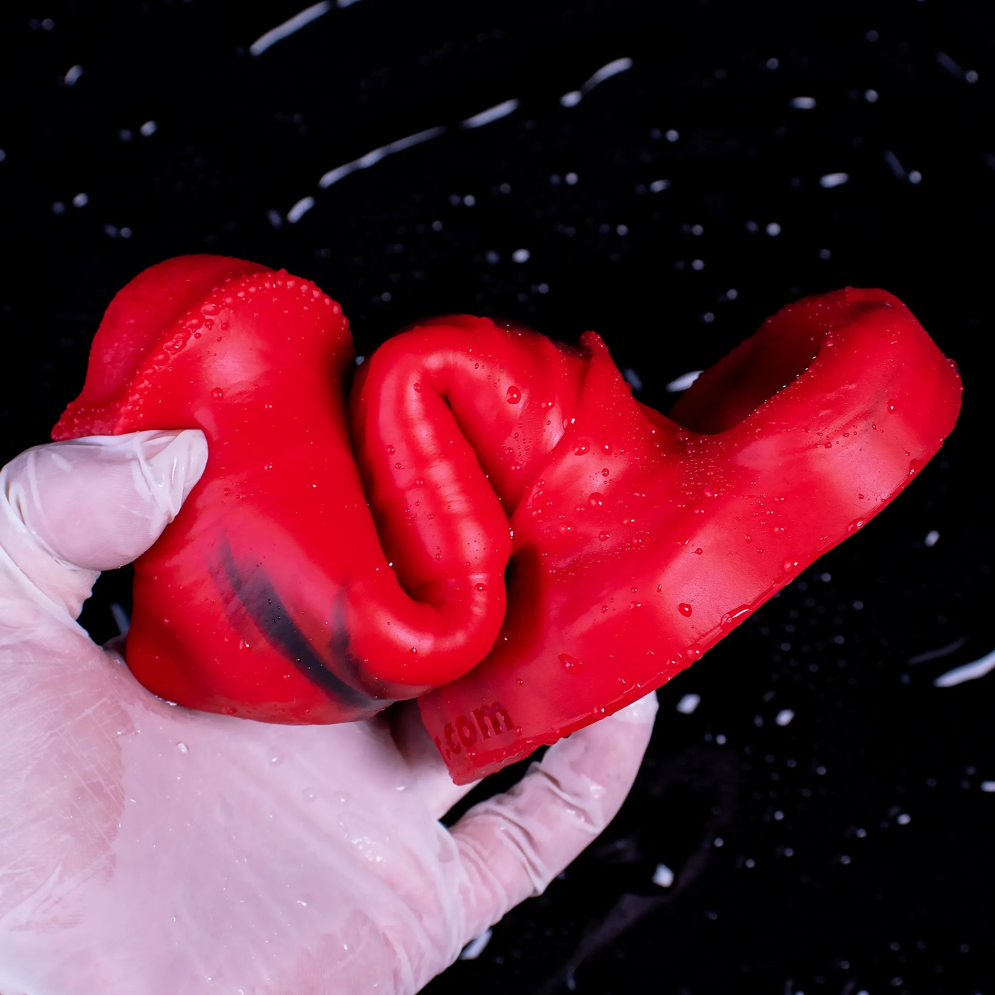 Red Oieffur male silicone penis sleeve, a girth and length extender, shown on a penis sheath for enhanced size and sensation.